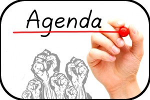 Hand underlining Agenda with red marker on transparent wipe board. 